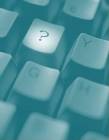 This image shows a close up view of a computer keyboard with a spotlight on the "question mark" key